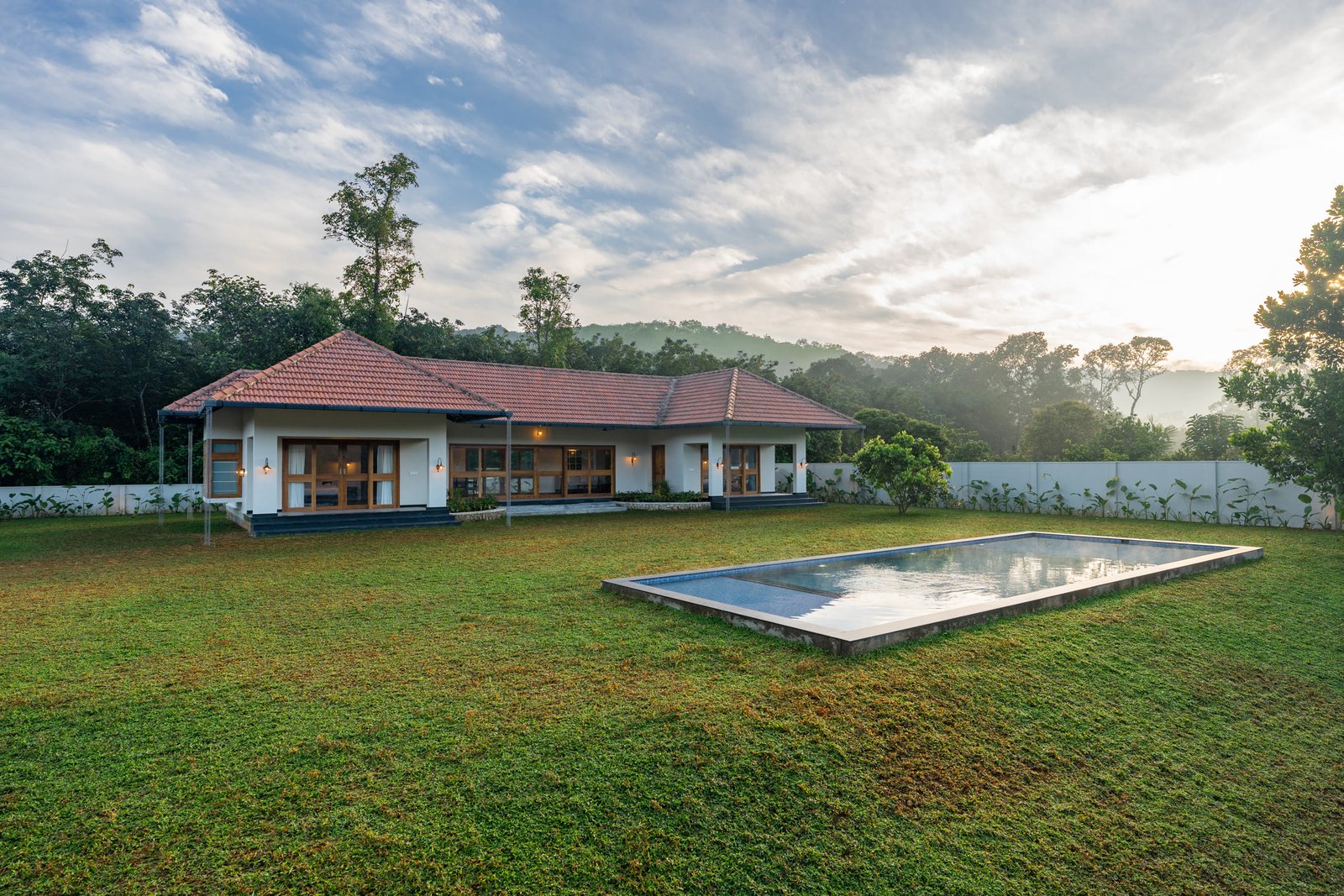 Wide daytime view of Planters Courtyard, its lawn and private pool