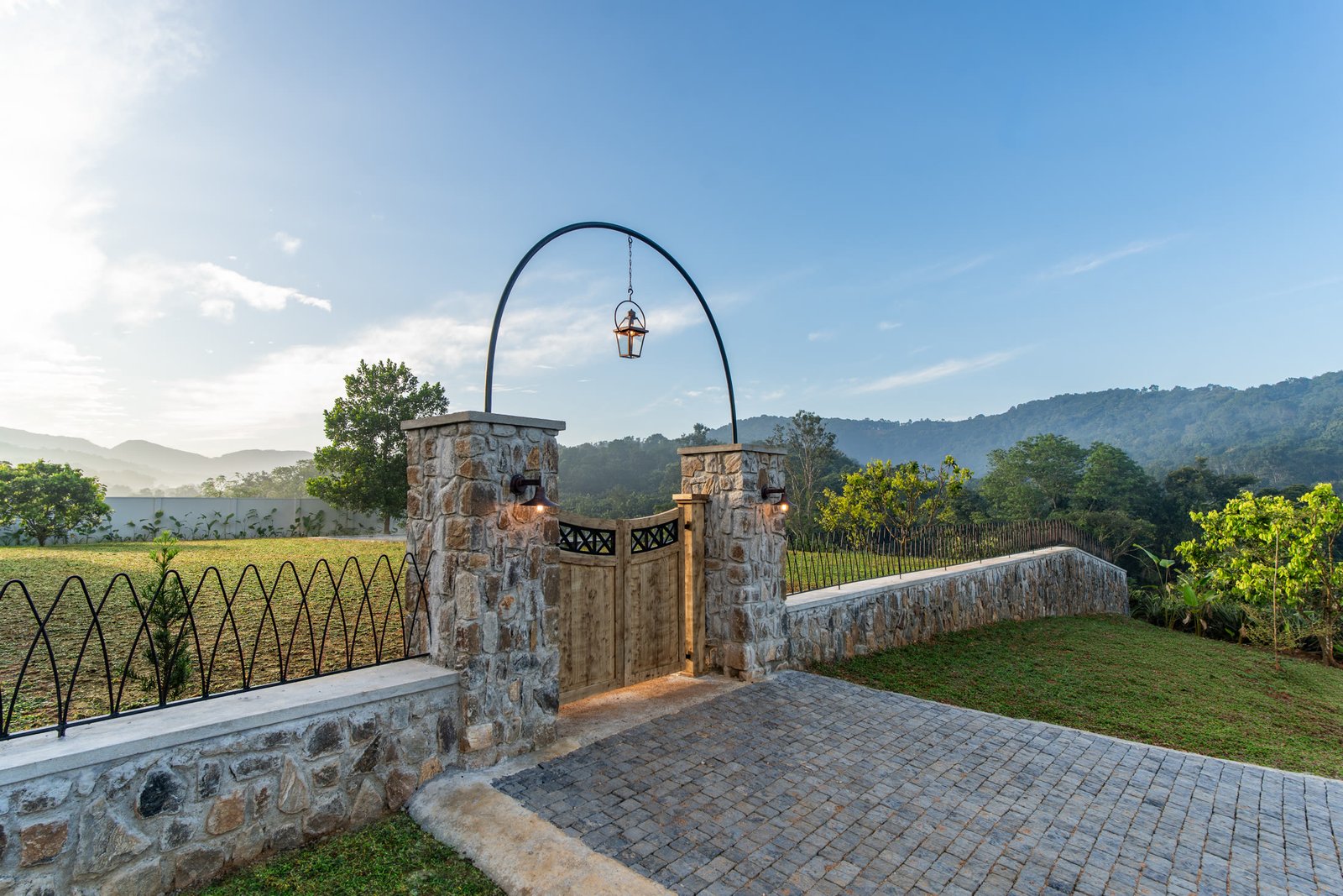 Estate gateway overlooking plantation greenery and hills