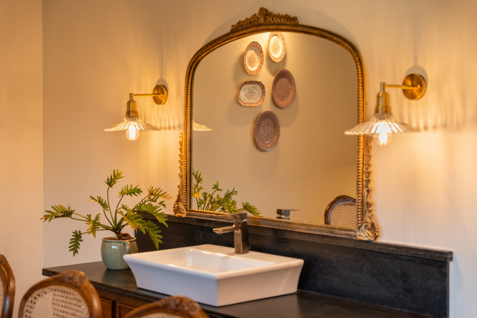 Decorative mirror, brass lighting and vanity basin