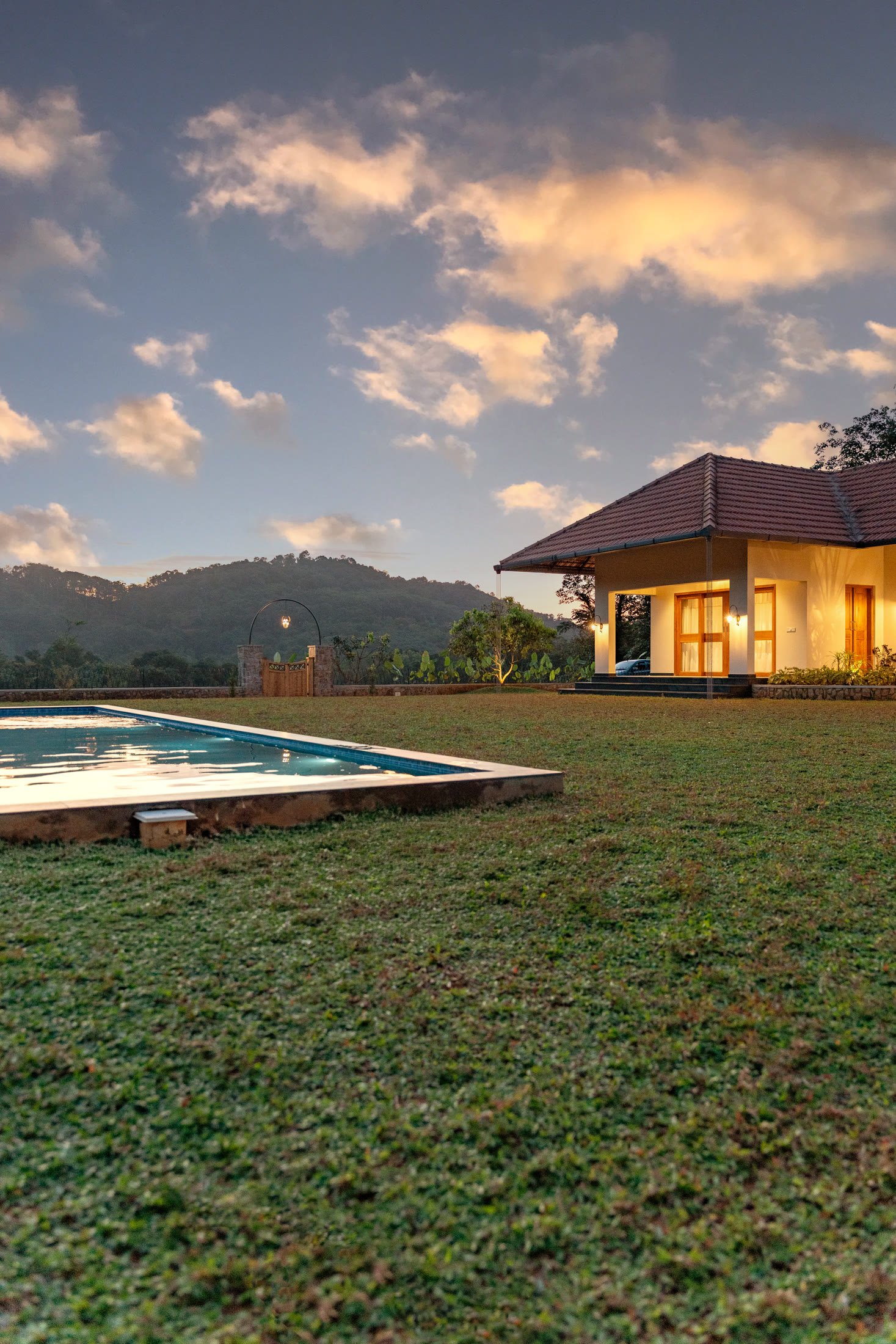 Portrait view of the farmhouse and pool at sunset