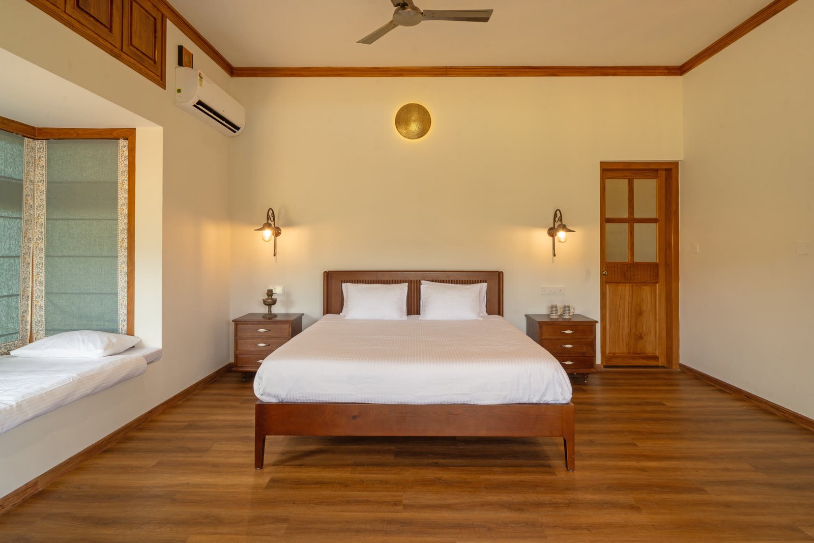 Spacious bedroom with timber flooring and window seating