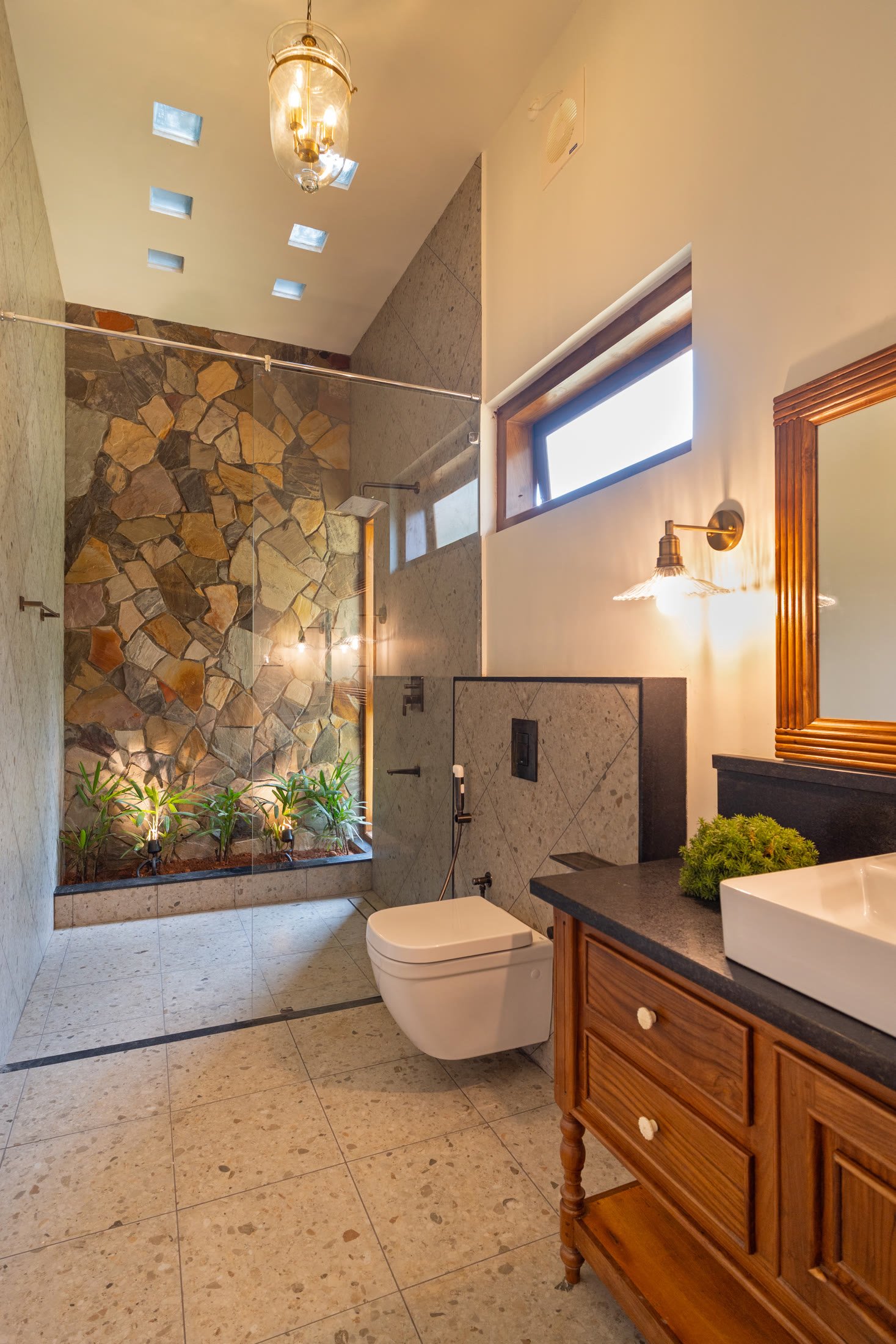 Large en-suite bathroom with stone wall and timber vanity