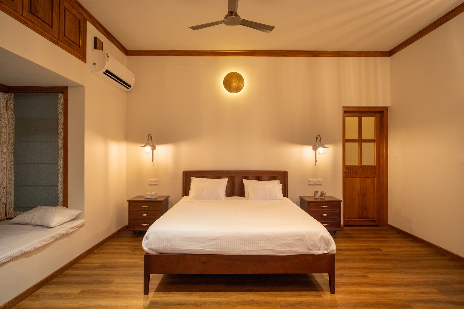 Second view of a warm bedroom with a deep window seat